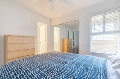 a bedroom with a blue bed and a large window at Daniel - Oceanview in Newport Beach
