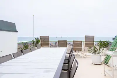 a long table on the beach with chairs at Beachfront Home in Newport Beach