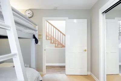 a bedroom with a bunk bed and a clock at Beachfront Home in Newport Beach
