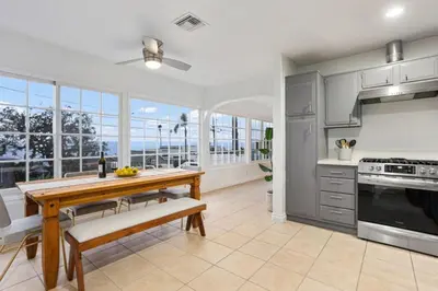 a kitchen with a wooden table and a dining room at The Pelican in Encinitas