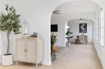 a hallway with white walls and a table with plants at The Pelican in Encinitas