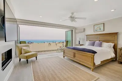 a bedroom with a bed and a view of a beach at 3312 W Oceanfront in Newport Beach