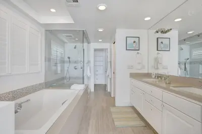 a white bathroom with two sinks and a shower at 3312 W Oceanfront in Newport Beach
