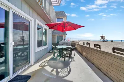 a table and chairs with an umbrella on a balcony at 3607 Seashore Dr A in Newport Beach