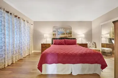 a bedroom with a bed with a red comforter at 3607 Seashore Dr A in Newport Beach