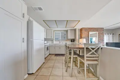 a kitchen with a table and a refrigerator at 3607 Seashore Dr A in Newport Beach