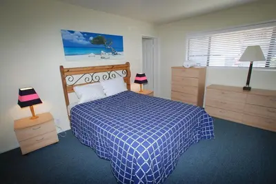 a bedroom with a blue and white bed and two dressers at 4212 Seashore Dr A in Newport Beach