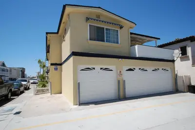a house with two garage doors on a street at 4212 Seashore Dr A in Newport Beach