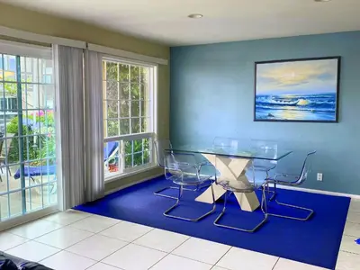 a dining room with a glass table and chairs at 4212 Seashore Dr A in Newport Beach