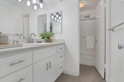 a white bathroom with a sink and a mirror at 5408 Seashore Dr A in Newport Beach
