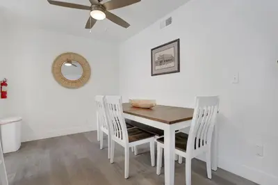 a white dining room with a white table and chairs at 5408 Seashore Dr A in Newport Beach