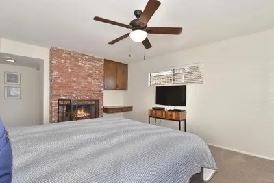 a bedroom with a ceiling fan and a fireplace at 925 W Bay Ave in Newport Beach