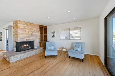 a living room with two chairs and a fireplace at 925 W Bay Ave in Newport Beach