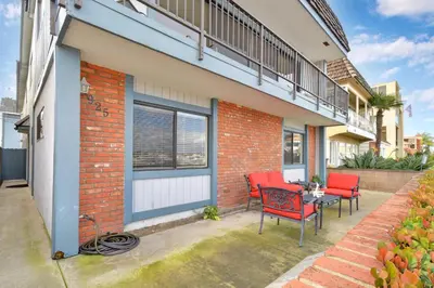 a patio with red chairs and a table in front of a building at 925 W Bay Ave in Newport Beach