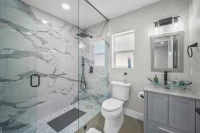 a bathroom with a toilet and a glass shower at Modern Oasis New 2BR in La Mesa in La Mesa