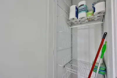 a refrigerator with a rack with cleaning products in it at Bungalow near zoo and beach with AC, EV, private yard in San Diego