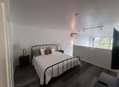 a white bedroom with a bed and a window at Beautiful Loft in Little Italy SD with Parking in San Diego