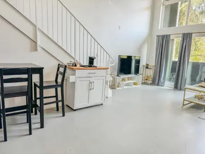 a living room with a staircase and a table and chairs at Beautiful Loft in Little Italy SD with Parking in San Diego