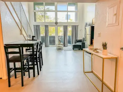 a living room with a table and chairs at Beautiful Loft in Little Italy SD with Parking in San Diego