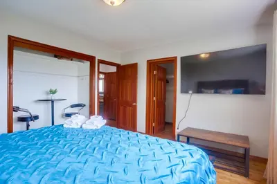 a bedroom with a blue bed and a table at 100 Yards Ocean & Surfing Ocean Views Backyard in San Diego