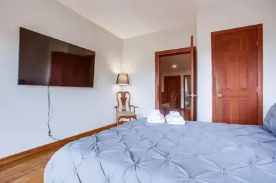 a bedroom with a large blue bed with a flat screen tv at 100 Yards Ocean & Surfing Ocean Views Backyard in San Diego