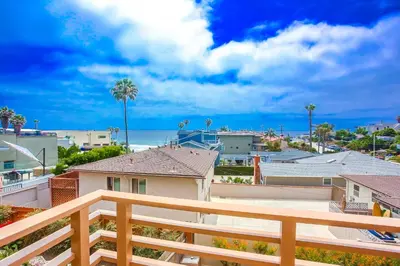 a balcony with a view of the beach and buildings at 100 Yards Ocean & Surfing Ocean Views Backyard in San Diego