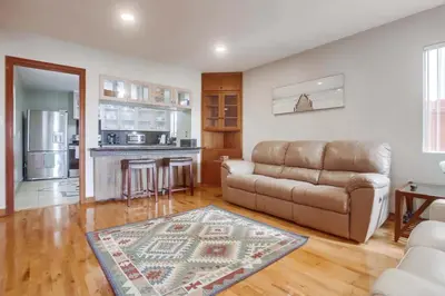 a living room with a couch and a kitchen at 100 Yards Ocean & Surfing Ocean Views Backyard in San Diego