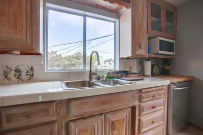 a kitchen with a sink and a window at Steps 2 Ocean & Surfing Ocean Views Rooftop Deck in San Diego
