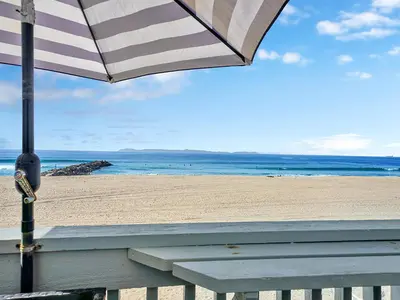 a beach with a bench and an umbrella at 3607 Seashore A & B in Newport Beach