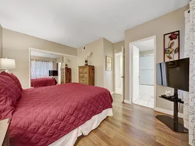 a bedroom with a large bed and a flat screen tv at 3607 Seashore A & B in Newport Beach