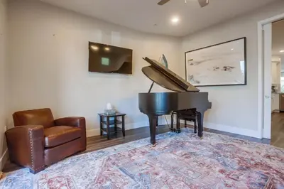 a living room with a piano and a chair at Ocean-view home blocks to beach with private hot tub & rooftop deck in San Diego