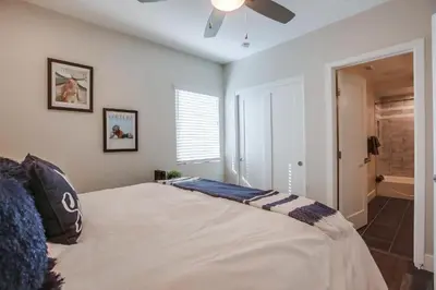 a bedroom with a large bed with a ceiling fan at Ocean-view home blocks to beach with private hot tub & rooftop deck in San Diego