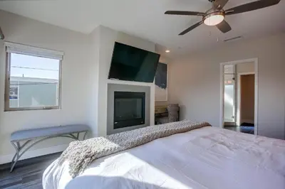 a bedroom with a bed and a flat screen tv at Ocean-view home blocks to beach with private hot tub & rooftop deck in San Diego