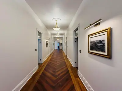 a hallway with white walls and wood floors and a painting on the wall at The Beau Hotel Downtown San Diego Gaslamp Quarter in San Diego
