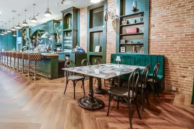 a restaurant with a table and chairs and a bar at The Beau Hotel Downtown San Diego Gaslamp Quarter in San Diego