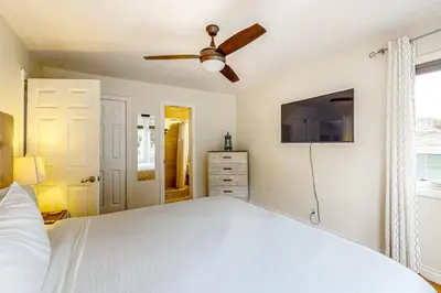 a bedroom with a white bed and a ceiling fan at Playa Del Sur Getaway La Jolla in San Diego