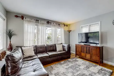a living room with a leather couch and a flat screen tv at Playa Del Sur Getaway La Jolla in San Diego