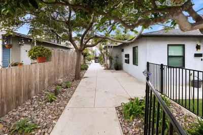 a sidewalk in front of a house with a fence at Modern Ocean Beach Apartment in San Diego