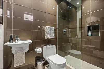 a bathroom with a toilet and a sink and a shower at Dana Point Luxe in Dana Point