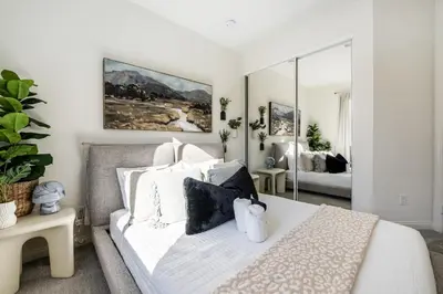 a bedroom with a white bed and a mirror at Brand New Stunning 4BR Townhome in Lemon Grove