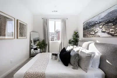 a white bedroom with a large bed with pillows at Brand New Stunning 4BR Townhome in Lemon Grove