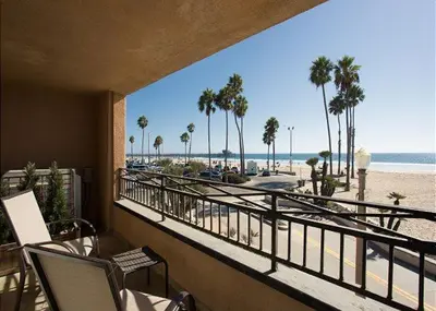 a balcony with a view of the beach and palm trees at 2314 W Oceanfront A & B in Newport Beach