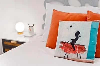 a bedroom with a bed with a pillow with a brick wall at Polk Casita by Rather Be Properties in San Diego
