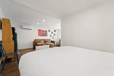 a bedroom with a white bed and a living room at Polk Casita by Rather Be Properties in San Diego