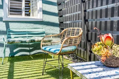 a wicker chair and a table on a patio at Polk Casita by Rather Be Properties in San Diego