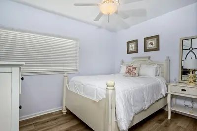 a bedroom with a white bed and a ceiling fan at Oceanfront Getaway, Private Beach, Fire Pit, 5BR in Oceanside