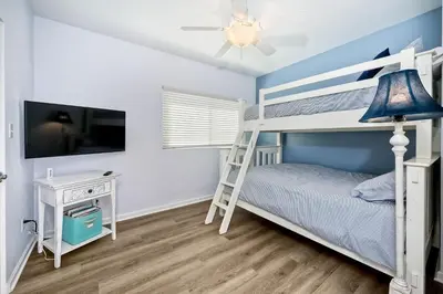 a bedroom with a bunk bed with a ladder at Oceanfront Getaway, Private Beach, Fire Pit, 5BR in Oceanside