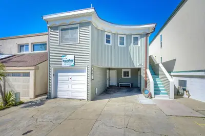 a large house with a garage and a driveway at Oceanfront Getaway, Private Beach, Fire Pit, 5BR in Oceanside