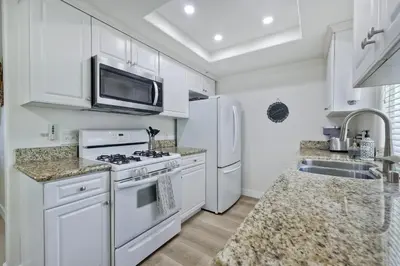 a white kitchen with a stove and a microwave at 1128 Tait Street, Unit D in Oceanside