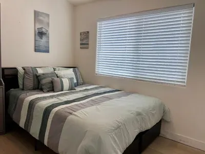 a bedroom with a bed and a window with blinds at 1128 Tait Street, Unit D in Oceanside